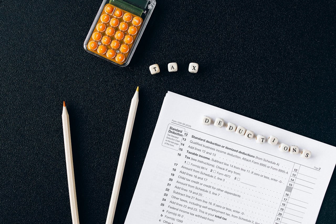 home-hero-bg Flat lay of tax form, pencils, and calculator on black background, emphasizing tax deductions.